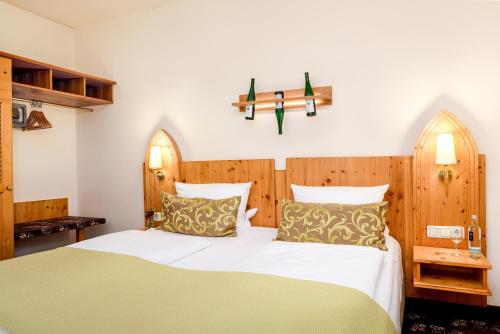 a bedroom with a bed and a cross on the wall at Akzent Waldhotel Rheingau in Geisenheim