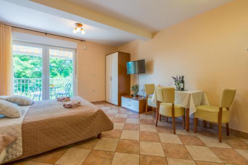a bedroom with a bed and a table and chairs at Amfora Apartments in Crikvenica