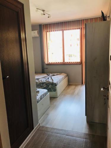 an empty room with two beds and a window at Семейна къща “Вълчеви” in Kiten