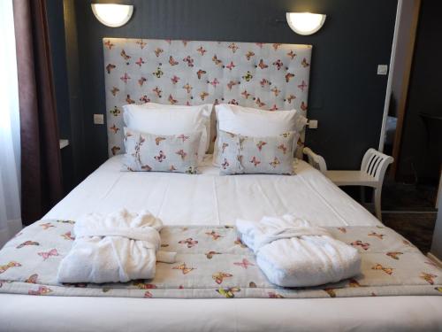 a bedroom with a bed with towels on it at Aux Temps d'Em in Montreuil-sur-Mer