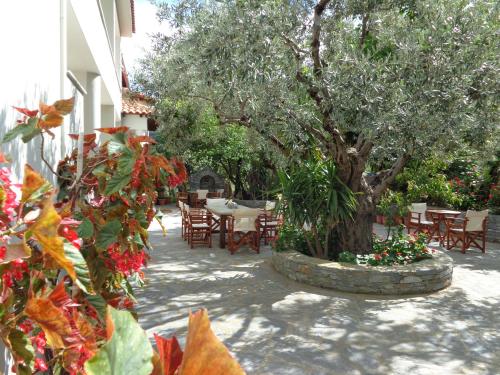 a patio with a table and chairs and a tree at Faros in Milopotamos