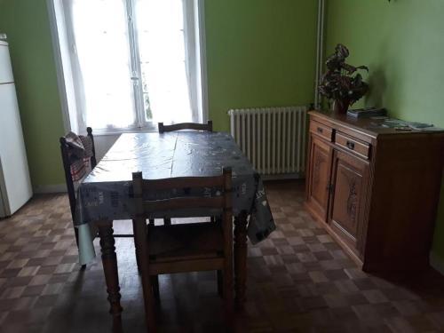 a dining room with a table and a wooden table and chairs at Chambre familliale in Questembert
