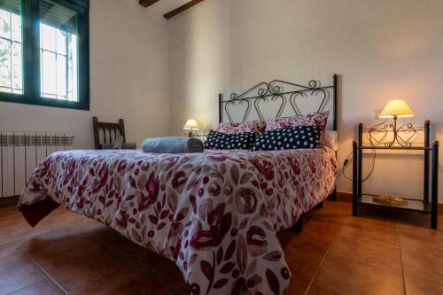 Schlafzimmer mit einem Bett mit einer roten und weißen Bettdecke in der Unterkunft Casa De Nohales in Nohales