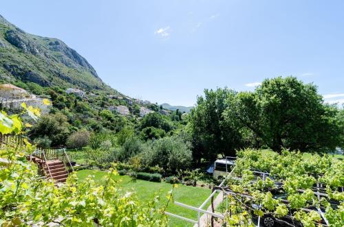 a view of a garden with mountains in the background at Apartments Tabain in Mlini