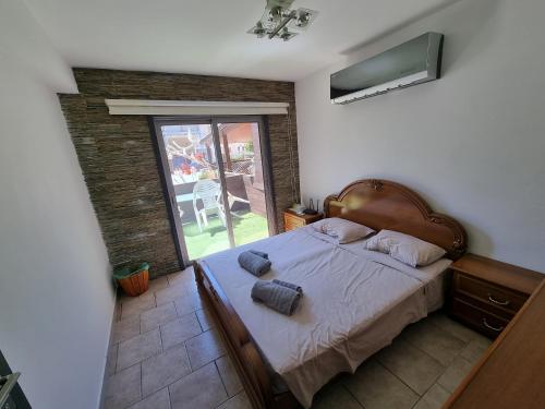 a bedroom with a bed and a window with a patio at Town centre suites in Larnaka