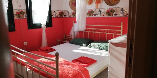 a red bedroom with a bed with red walls at Olgas Villa in Aroyí
