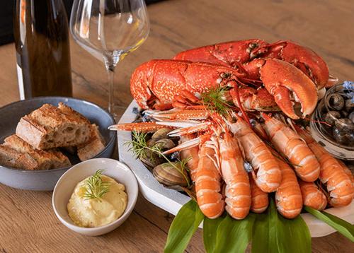 a plate of lobsters and other foods on a table at CAP HOUSES "FAMILY" in Erquy