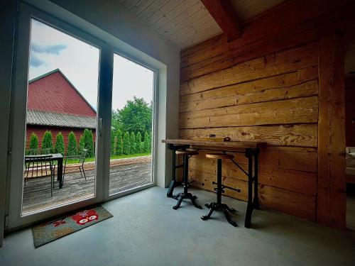 Habitación con ventana grande y pared de madera. en Plateliai Samogitia Barn en Plateliai