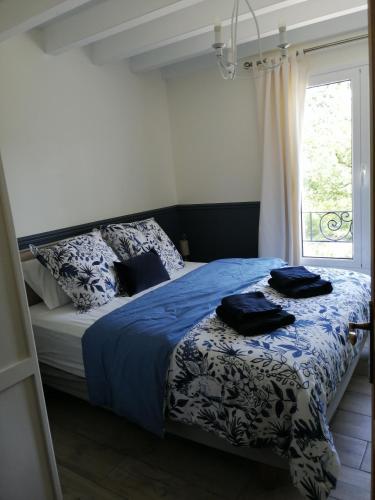 une chambre avec un lit avec des draps bleus et une fenêtre dans l'établissement VILLA XARAN ERDIAN Gîte LA PETITE MAISON, à Espelette