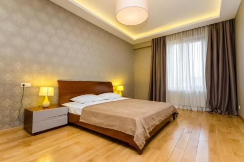 ein Schlafzimmer mit einem Bett und einem großen Fenster in der Unterkunft Premium 2 Bedroom Apartment in Tbilisi City