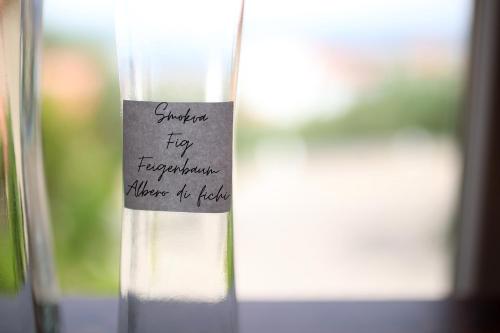 a glass with a piece of writing on the side of it at Hotel Murter in Murter