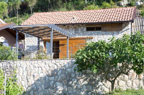 a house with a stone wall in front of a house at Kamena Kuća Hutovo Blato in Čapljina