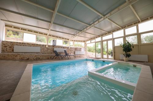 a large swimming pool in a building with windows at Hotel Murter in Murter