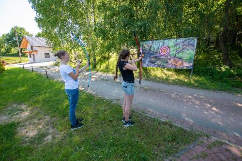 two children playing with a kite in the grass at DOMKI - Kaszuby Resort ZACISZE - new cottage in Chmielno