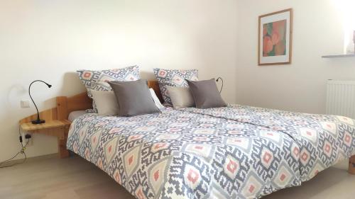 a bedroom with a bed with a colorful comforter at Schau-Rhein#2 - on Top of Bacharach, Rhineview in Bacharach