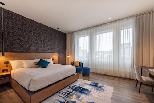 a bedroom with a large bed and a desk and a table at Hotel Royal William, an Ascend Collection Hotel in Quebec City