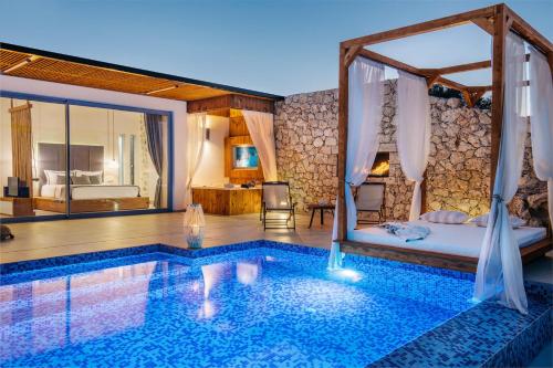 a hotel room with a pool and a bed and a bedroom at Emerald Villas & Suites - The Finest Hotels Of The World in Agios Nikolaos