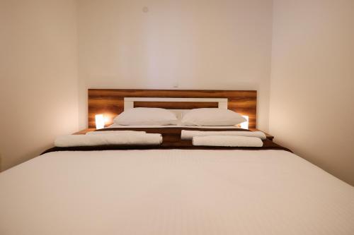 a large white bed with two pillows on it at Hotel Murter in Murter
