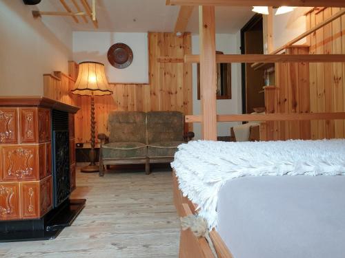 a bedroom with a bed and a chair and a lamp at Alm-Ferienhaus Gaisegg am Klippitztörl in Bad Sankt Leonhard im Lavanttal