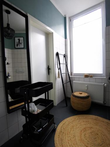 a bathroom with a large mirror and a stool at Quedlinburg Marktplatz-Suites in Quedlinburg