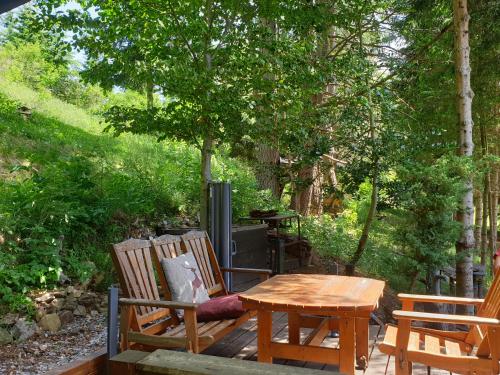 a wooden table and chairs on a wooden deck at Alm-Ferienhaus Gaisegg am Klippitztörl in Bad Sankt Leonhard im Lavanttal
