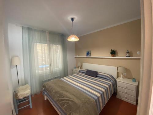 een kleine slaapkamer met een bed en een raam bij DOFI 1 in Tamariu
