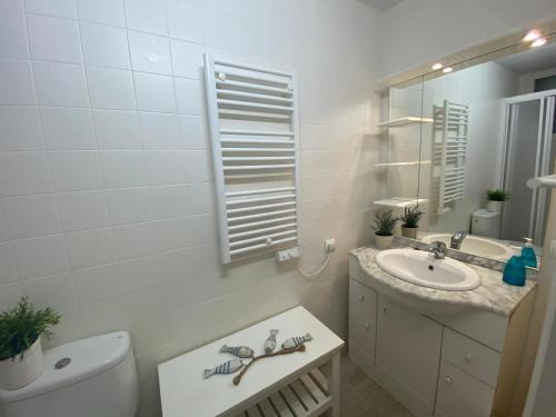 een badkamer met een wastafel, een toilet en een spiegel bij DOFI 1 in Tamariu