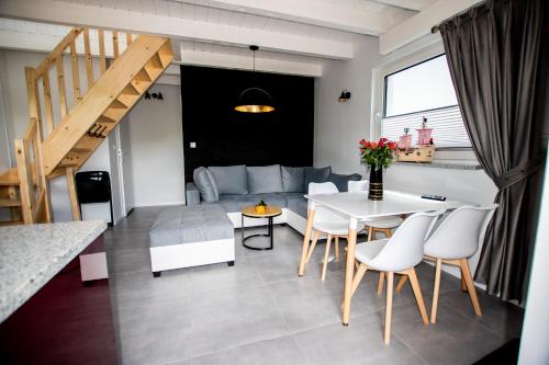 a living room with a table and a couch at DOMKI - Kaszuby Resort ZACISZE - new cottage in Chmielno