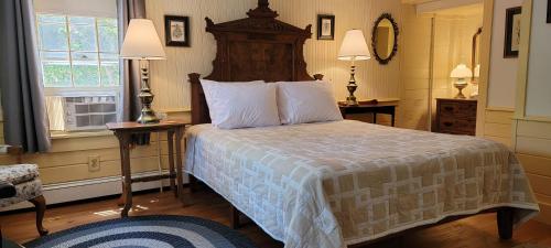 a bedroom with a bed and two tables and two lamps at Hawks House Inn in Walpole