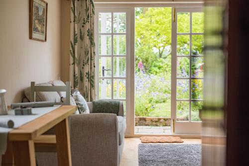 a living room with a door open to a garden at Plum Pudding Stables by Bloom Stays in Faversham