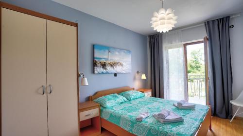 Un dormitorio con una cama con paredes azules y una ventana en Guest House Ambienti, en Rovinj