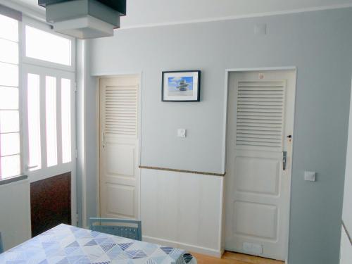 um quarto com duas portas brancas e uma mesa em Arade Rooms em Parchal