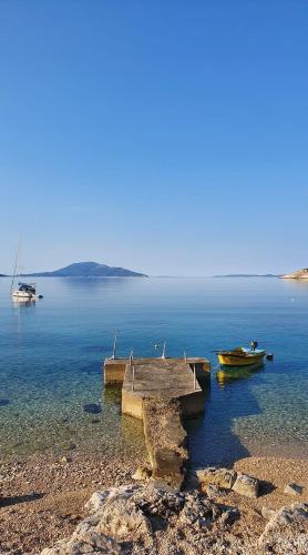 a dock with two boats on a large body of water at VILLA IL BLU direkt am Meer in Martinšćica