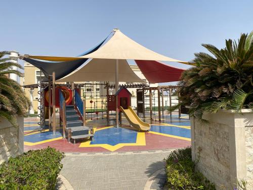 einen Spielplatz mit Rutsche und Rutsche in der Unterkunft شقة الواحة روز - Alwaha Rose in King Abdullah Economic City