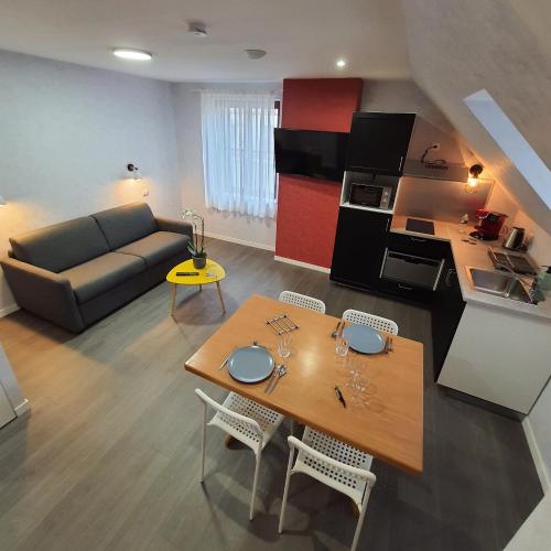 un salon avec une table et un canapé dans l'établissement La Potinière Du Lac Appartements, à Bagnoles-de-l'Orne