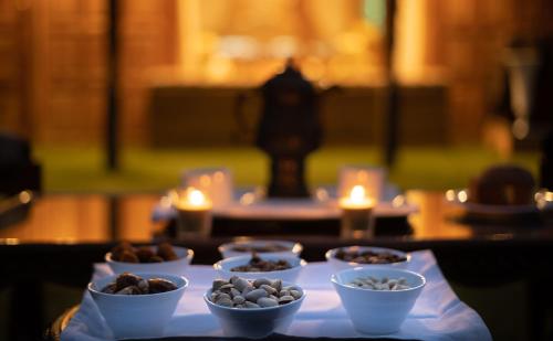 WelcomHeritage Gurkha Houseboats في Srīnagar: طاولة مع أطباق من الطعام على طاولة مع الشموع