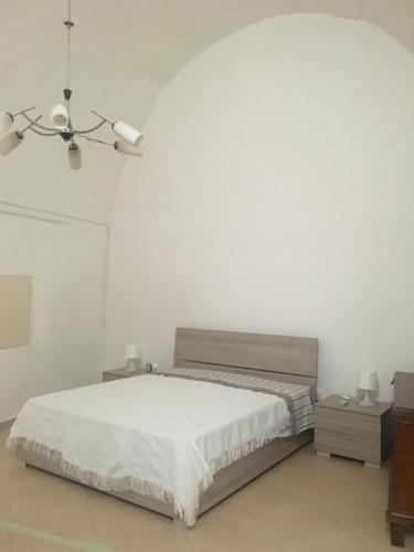 een witte slaapkamer met een bed en een plafondventilator bij Salento, casa tipica in Sternatia