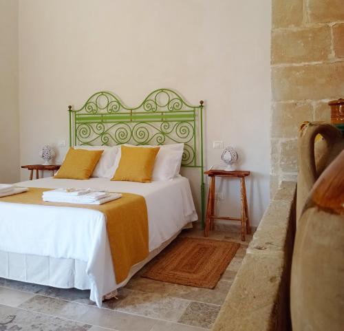 - une chambre avec un grand lit et une tête de lit verte dans l'établissement Giardino Frannicola, à Maglie