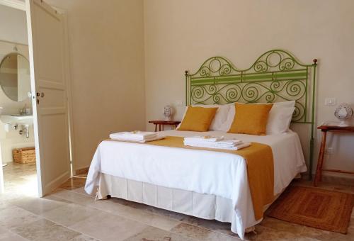 a bedroom with a large bed with a green headboard at Giardino Frannicola in Maglie