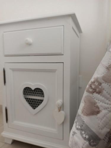 a white cabinet with a heart on it next to a bed at Romantico Rifugio in Guardiagrele