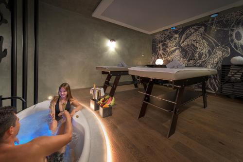 Ein Mann und eine Frau in einer Badewanne in der Unterkunft Olympic Palace Hotel in Ixia