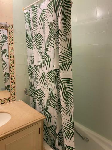 コスタ・ダ・カパリカにあるCosta Marのバスルーム(緑と白の葉柄のシャワーカーテン付)