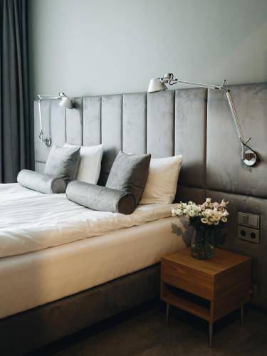 a bed with pillows on it with a lamp and a table at RATUSZOVA Stary Rynek Old Market PREMIUM Apartments & Restaurant AD 1954 in Poznań
