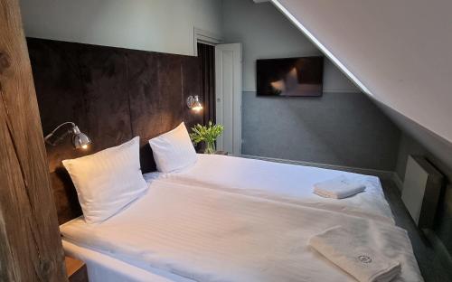 a bed with white sheets and pillows in a room at RATUSZOVA Stary Rynek Old Market PREMIUM Apartments & Restaurant AD 1954 in Poznań