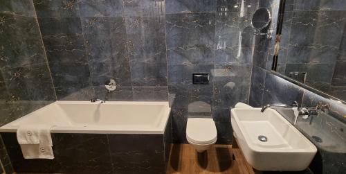 a bathroom with a sink and a toilet at RATUSZOVA Stary Rynek Old Market PREMIUM Apartments & Restaurant AD 1954 in Poznań