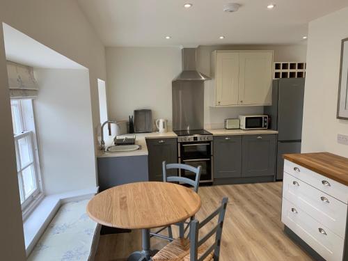 a kitchen with a wooden table and a small table and chairs at The Bothy at Arndean in Dollar