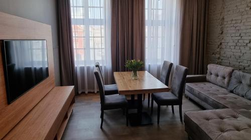 a living room with a table and a couch at RATUSZOVA Stary Rynek Old Market PREMIUM Apartments & Restaurant AD 1954 in Poznań