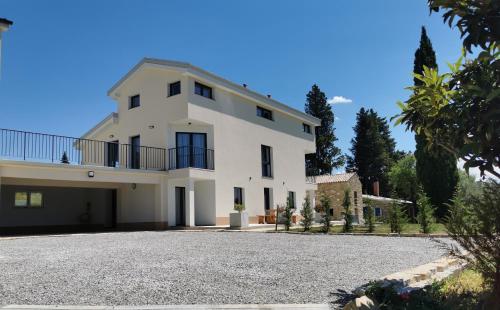 une grande maison blanche avec une allée. dans l'établissement Apartments Casa Tijola, à Sečovlje