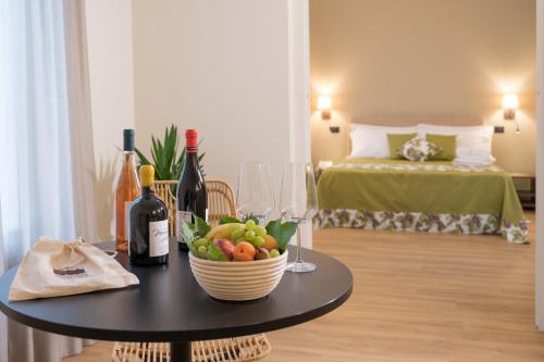 a table with a bowl of fruit and wine bottles at Santoro Country House in Castiglione di Sicilia
