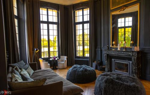 a living room with a couch and a fireplace at Les Garennes - Hôtel Spa Bénodet in Bénodet